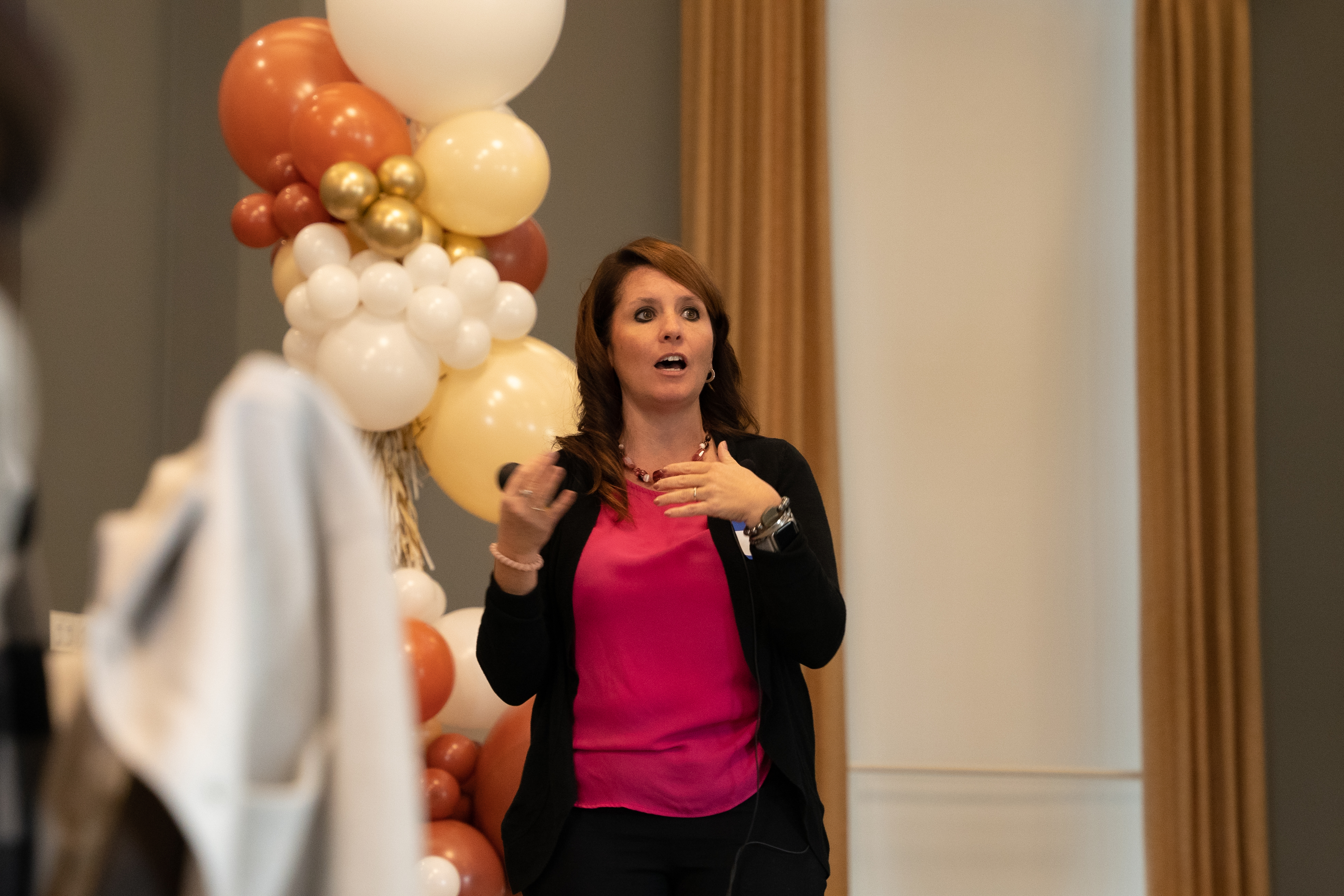 Kim speaking in front of balloons